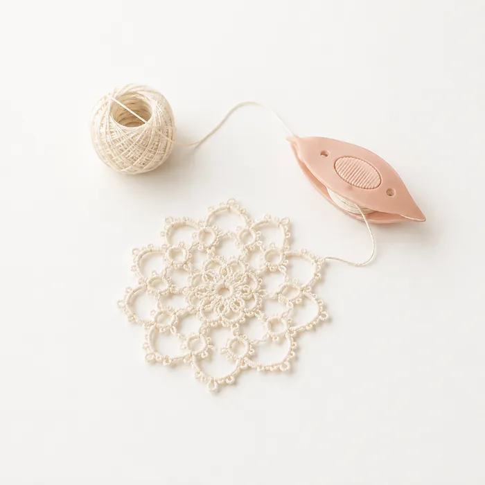Tatting shuttle thread and lace motif